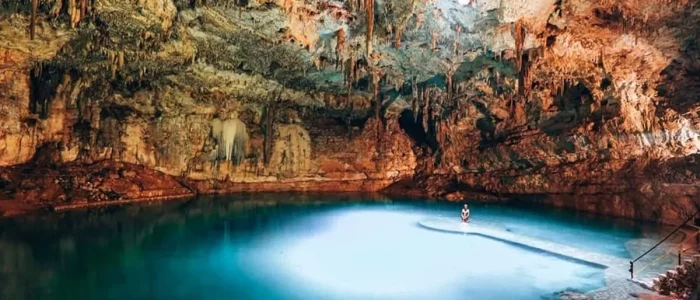 Voyageur contemplant la lumière dans le cénote Suytun