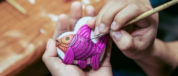 artisan peignant un alebrije à OaxAaca